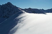 Tatry , zima, Kasprowy Wierch, widoczny wal halnego i chmury przelewajace przez Gran Glowna Tatr. W tle Swinica.