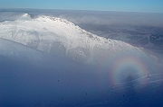 Tatry , zima, Kasprowy Wierch, widok na Giewont, widoczne Widmo Brockenu. Mamidlo gorskie, zjawisko Brockenu - rzadkie zjawisko optyczne spotykane w gorach, polegajace na odbiciu powiekszonego cienia obserwatora, niekiedy z teczowa obwodka (gloria), na chmurze. Nisko polozona chmura pelni role ekranu, jesli obserwator znajdzie sie miedzy nia a sloncem. Nazwa zjawiska podchodzi od szczytu Brocken w gorach Harz, gdzie po raz pierwszy zostalo zaobserwowane.